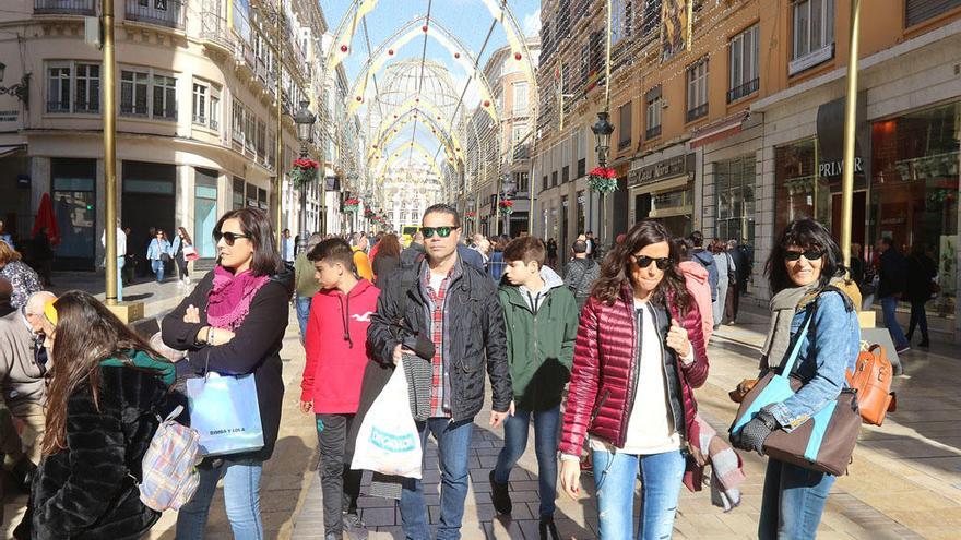 Gente paseando en una soleada calle Larios.