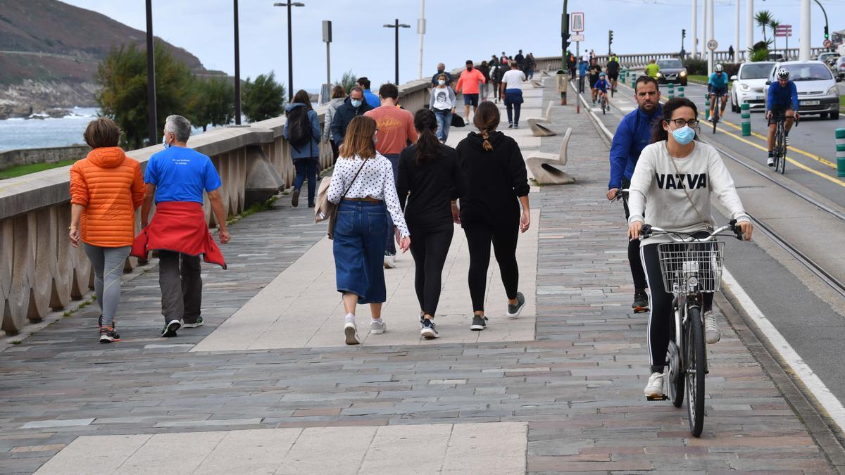 Ciudadanos con mascarilla en el paseo marítimo de A Coruña.