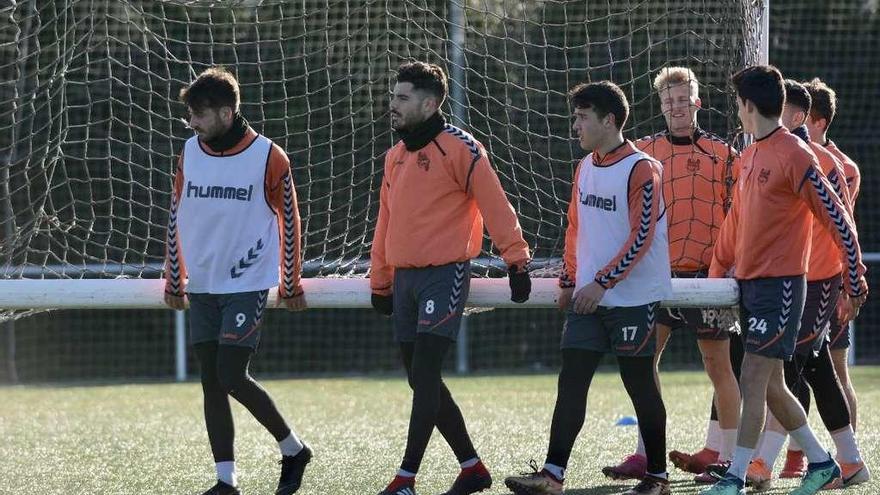 Jugadores del Pontevedra trasladando una portería en el entrenamiento de ayer en Cerponzóns. // Rafa Vázquez