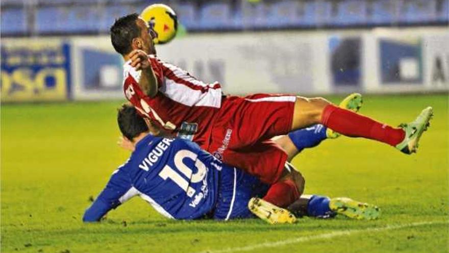 El defensa i capità del Girona Migue cau per terra amb el davanter de l&#039;Alabès, Borja Viguera, en una jugada del partit de dissabte a Mendizorrotza (1-1).