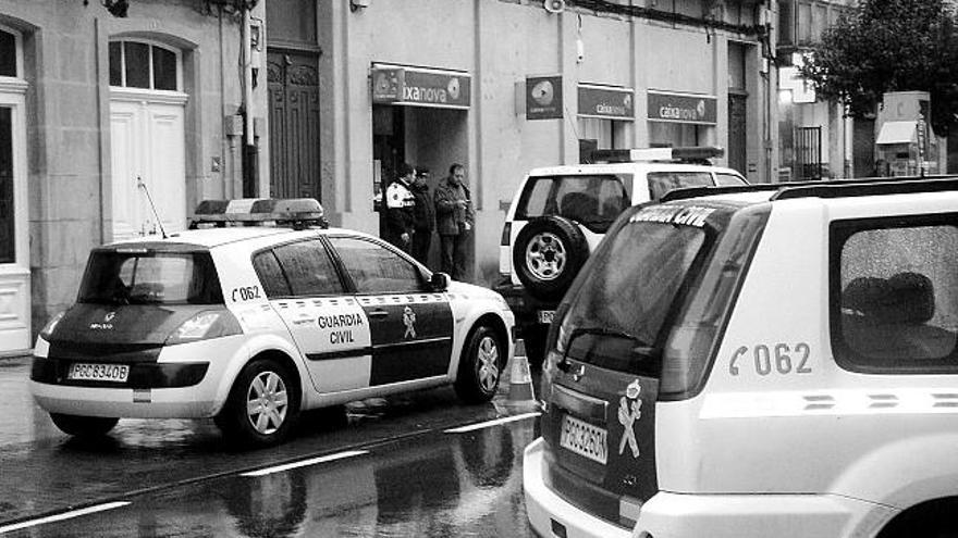 Los agentes de la Guardia Civil vigilan la entidad bancaria asaltada en A Estrada