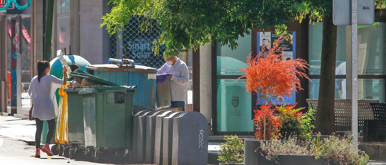 Ciudadanos utilizan los contenedores de orgánicos y de papel y cartón de la calle Arzobispo Lago.