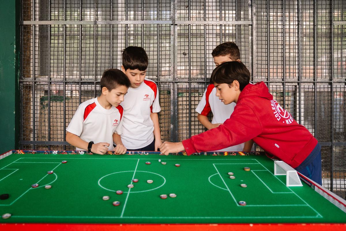 Niños juegan al fútbol chapa en el Colegio Claret de Madrid.