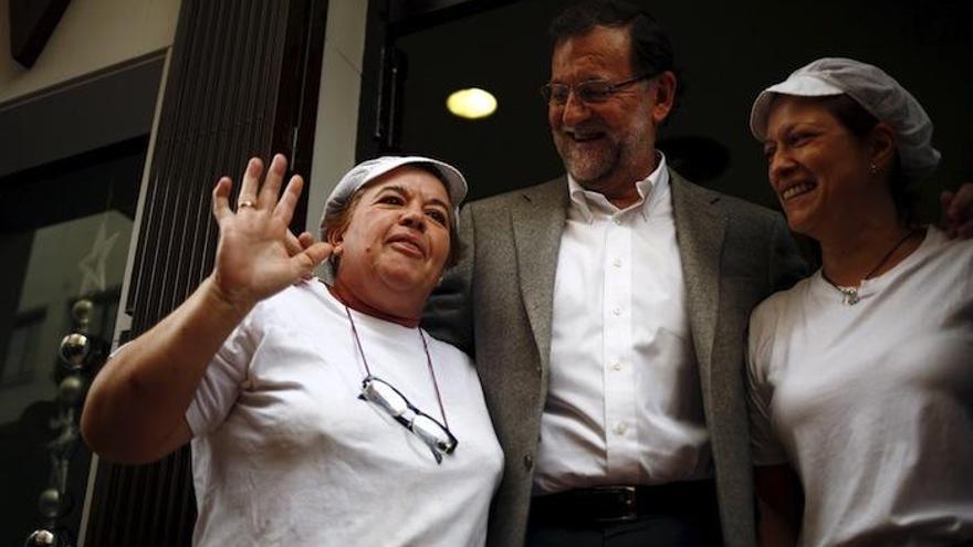 Rajoy, con dos empleadas de un bar, durante su paseo por las calles de Estepona.