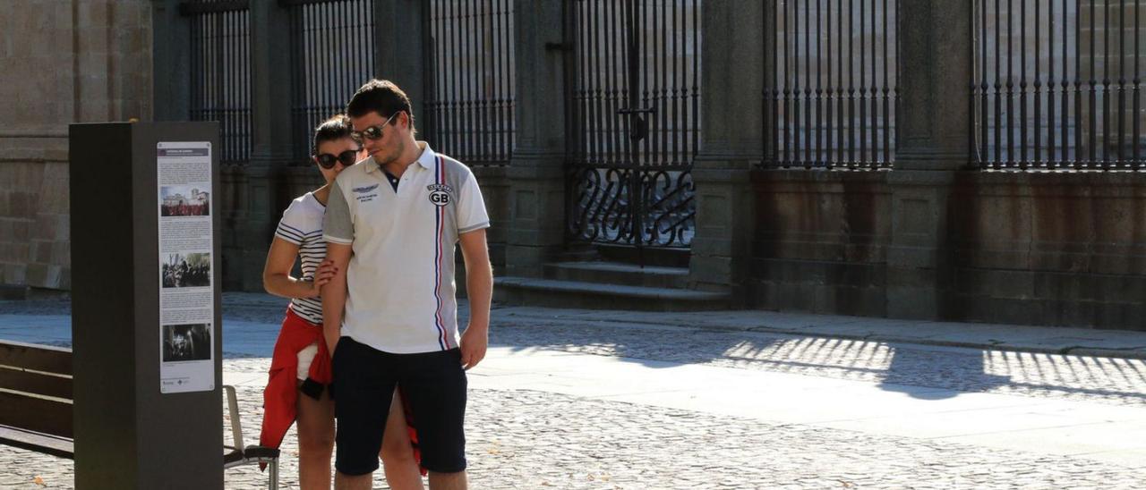 Una pareja lee atentamente la información turística en la plaza de la Catedral. | Jose Luis Fernández