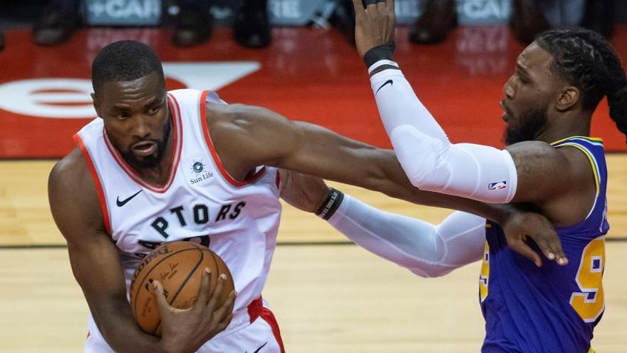 Serge Ibaka (i) de los Raptors ante Jae Crowder de los Jazz.