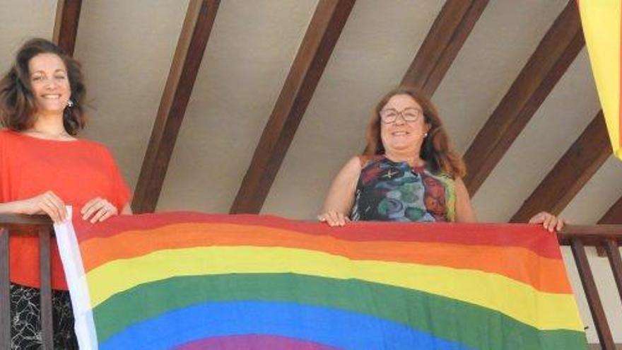 Vanessa Parellada y Azucena Carrasco con la bandera LGTBI en el balcón del Consell.