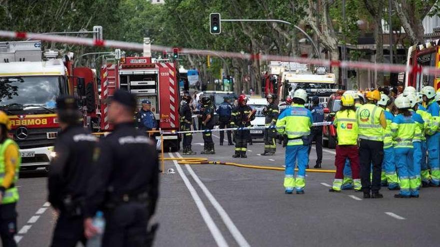 Bomberos, policías y voluntarios en la calle de Madrid donde se vino abajo el edificio.