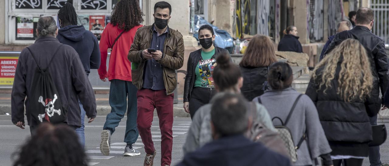 Ciudadanos con mascarilla cruzan las Avenidas  por un paso de peatones