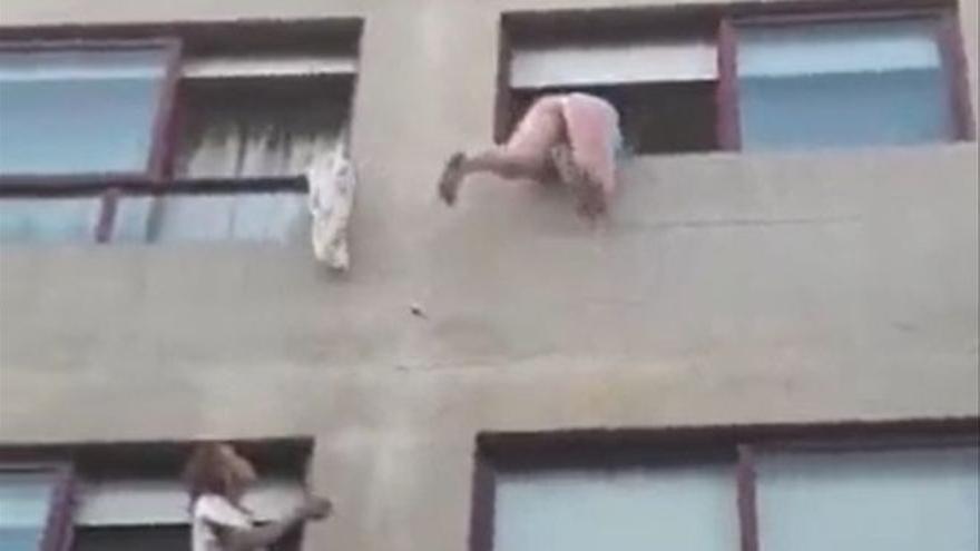 La Policía rescata a una mujer a punto de caer por el balcón.