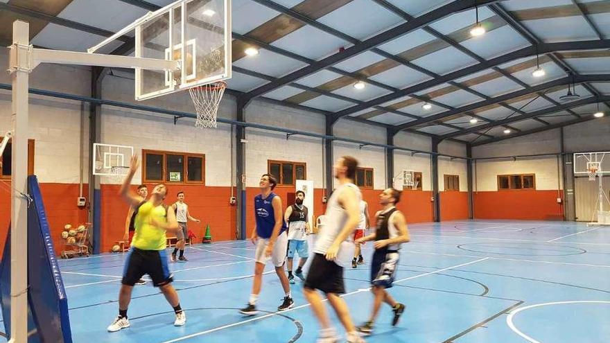 Jóvenes practicando baloncesto en Navia.