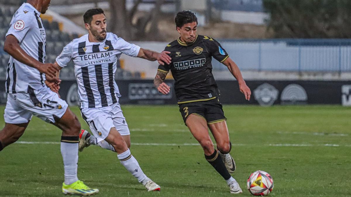 Cristo Romero ejecuta un disparo que intenta obstaculizar Sergio Moyita, del CD Castellón, en el Nuevo Castalia