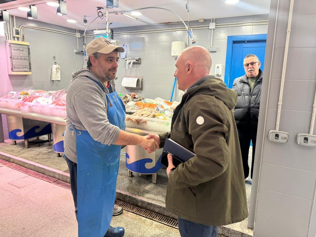 Hugo González le estrecha la mano a Abel Junquera en la nueva pescadería de La Camocha.