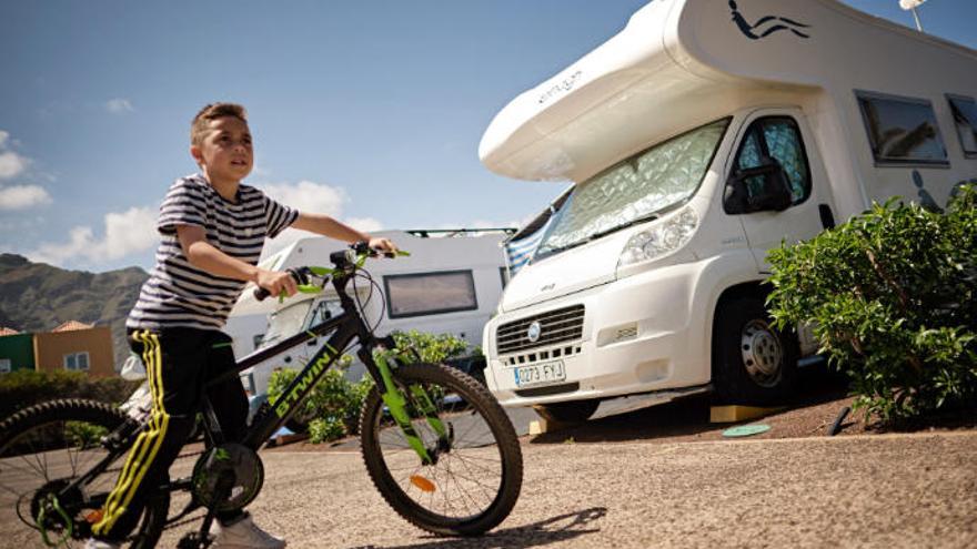 El niño con su bicicleta delante de la autocaravana familiar.