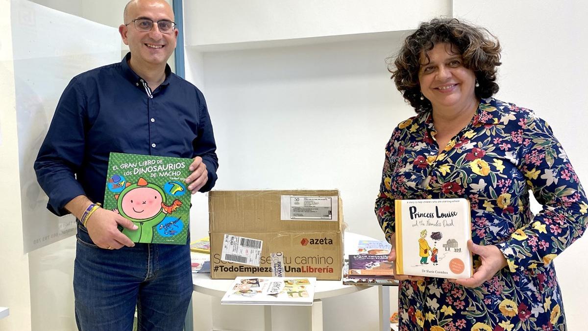 El edil Manuel López desembala un pedido a la Librería Proteo, junto a una colaboradora.