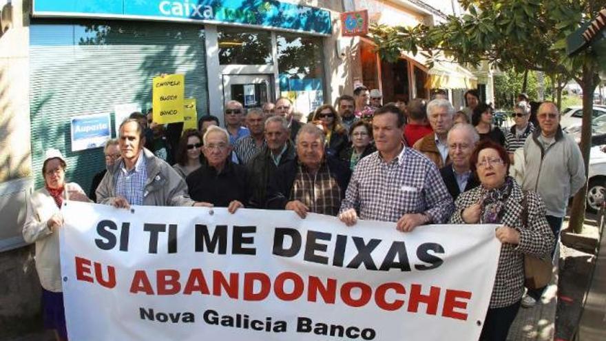 Los vecinos de Chapela, ayer tarde, durante su protesta ante la sucursal que cerrará este martes.  // R. Grobas