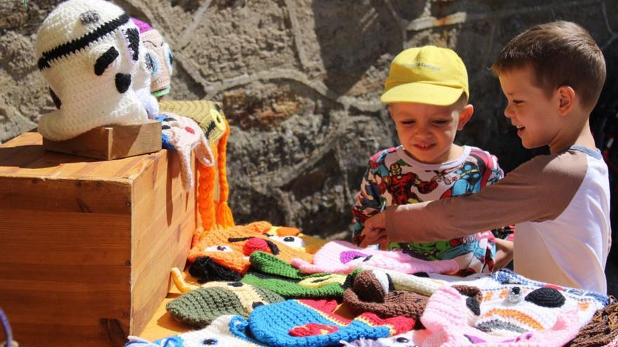 Dos inños admiran un puesto de gorros tejidos a mano. | Araceli Saavedra