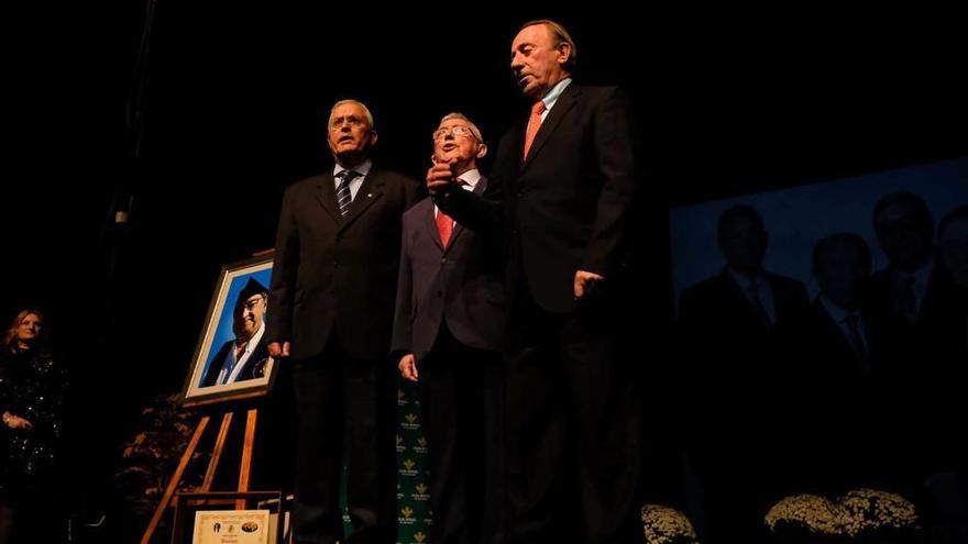 Arsenio Fernández-Nespral, Roberto González y Luis Estrada, junto al retrato de Emilio García, en su última actuación, en el teatro de La Felguera.