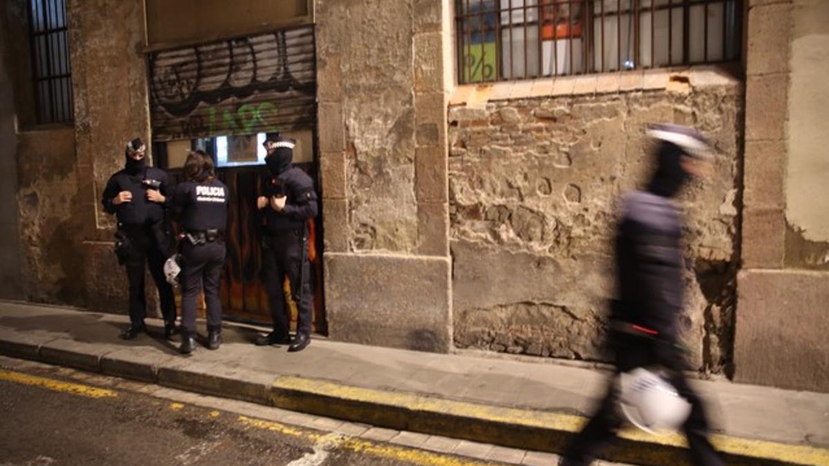 Varios agentes montan guardia ante uno de los locales registrados, en la calle Erasme del Raval.