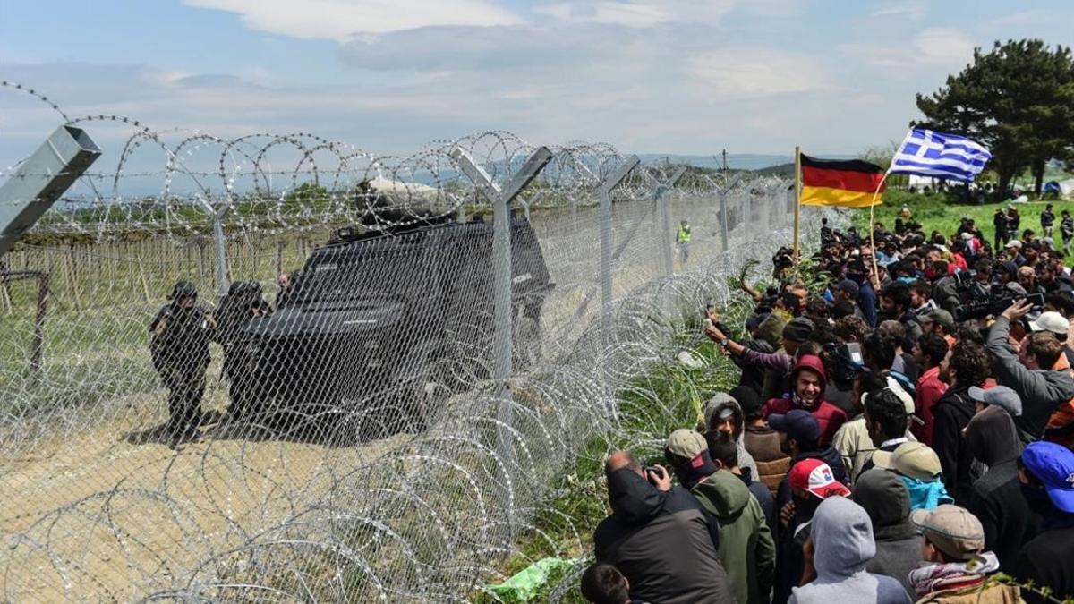 Refugiados y migrantes junto a la valla que separa Grecia y Macedonia, cerca de Idomeni, reclaman la apertura del paso fronterizo, el 11 de abril.