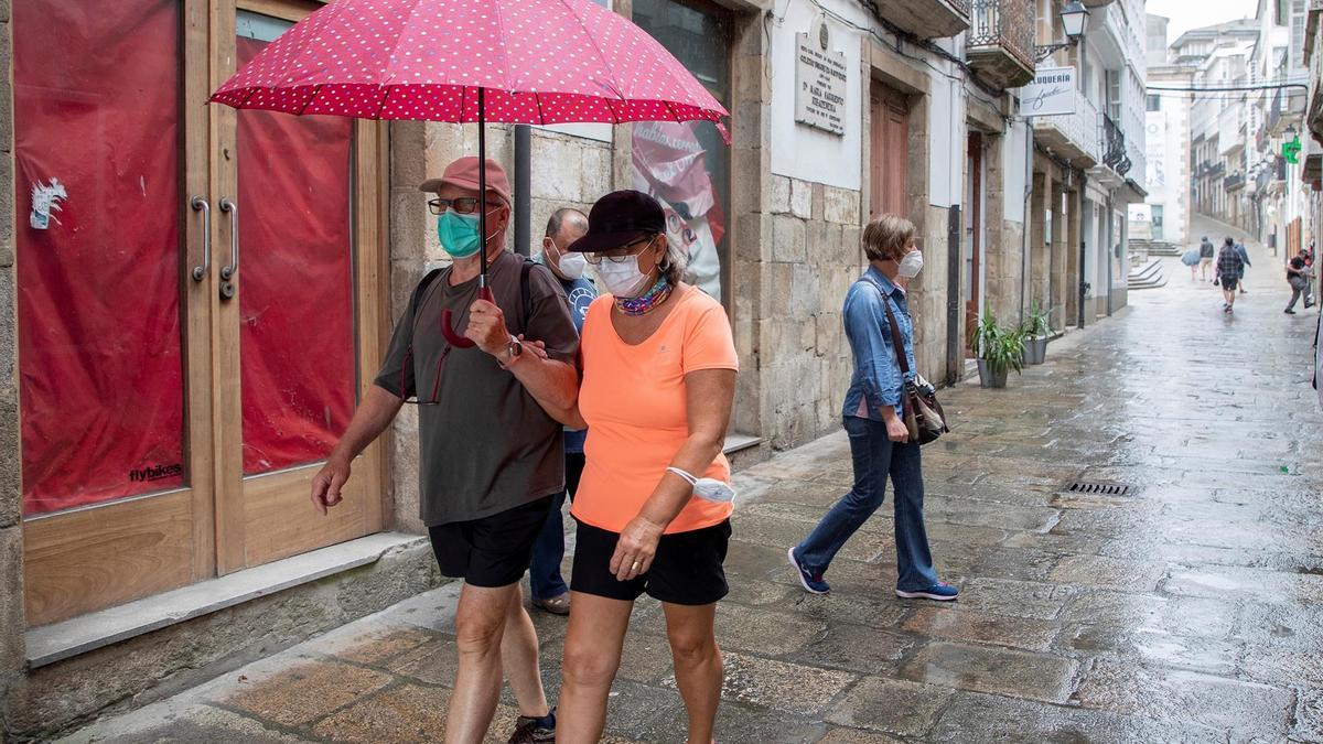 Dos viandantes se protegen de la lluvia