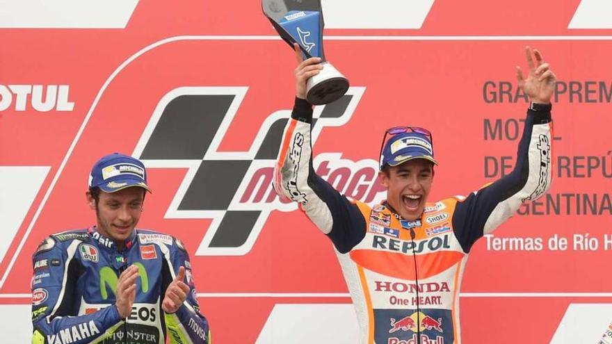 Marc Márquez festeja su triunfo mientras Valentino Rossi aplaude. // Efe