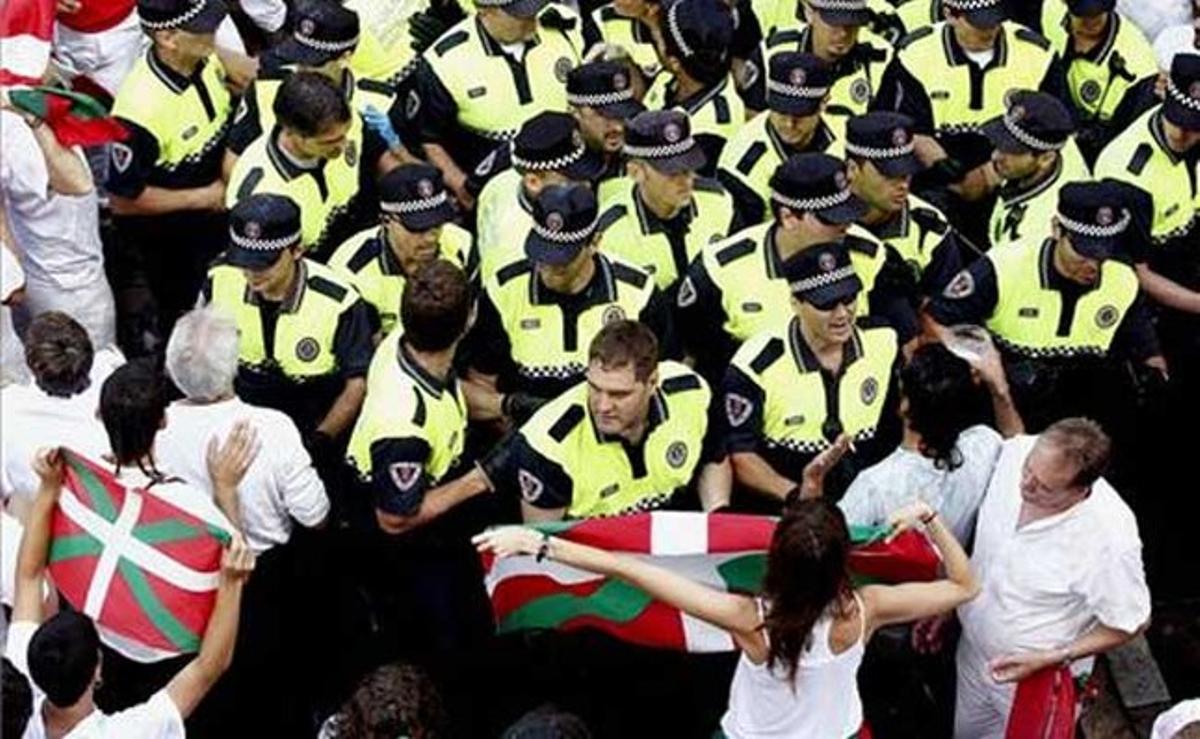 Agents de la policia local abandonen la plaça de l’Ajuntament de Pamplona sense impedir l’accés d’una ’ikurriña’ a la zona, després del tradicional ’chupinazo’.