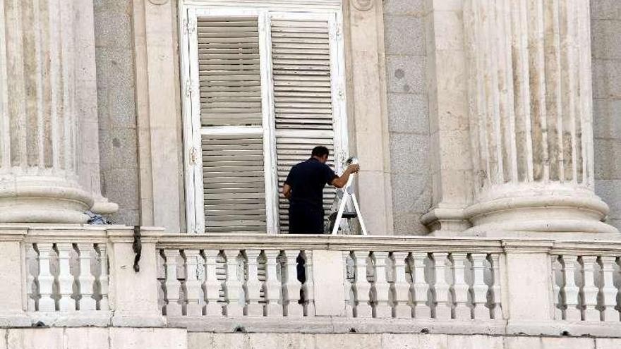 Un trabajador ultima los detalles en el balcón principal del Palacio Real.