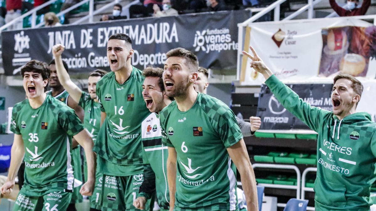 Jugadores del Cáceres celebran en el banquillo una canasta de sus compañeros.