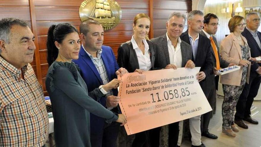 Fernando García, Lorena Terrones, Manuel Guerra, Sandra Ibarra, Juan Ramón Lucas, Fernando Quintana, José Pablo Berros, subdirector de Salud Pública del área del Noroccidente, Sonia Álvarez y José Ángel Pérez, alcalde de Castropol, con el cheque de la donación del cross de Figueras.