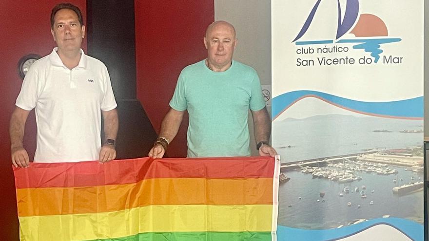 Javier Domínguez y el comodoro Carlos Núñez muestran la bandera multicolor