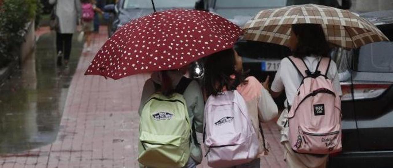 Escolares con paraguas, ayer, a la salida del colegio en Vigo.