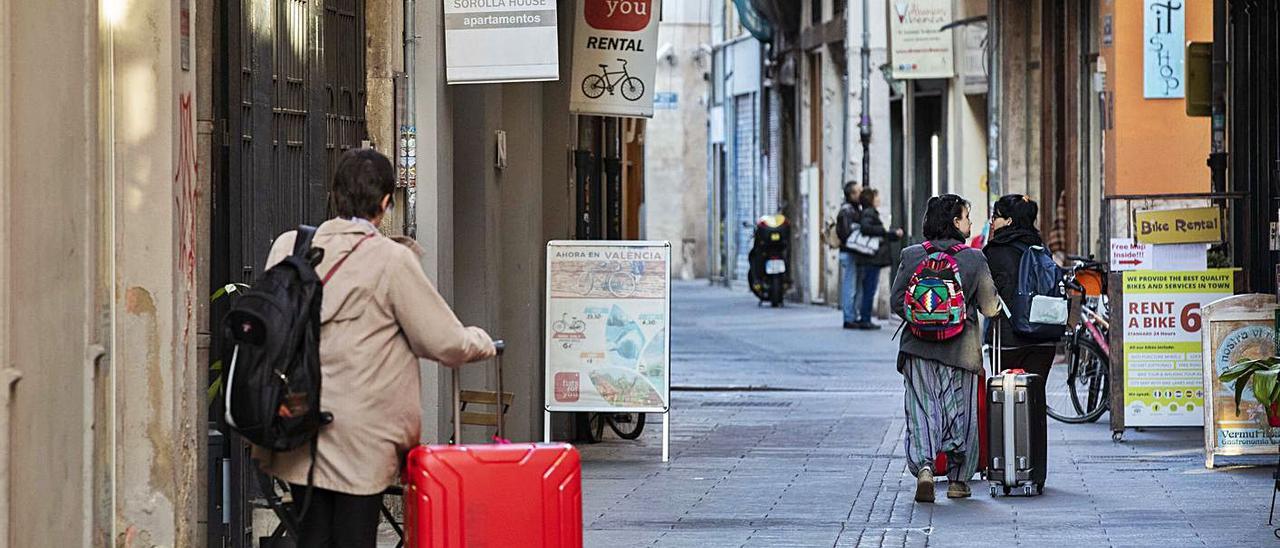 Turistas en una calle con pisos de alquiler vacacional en el centro de València, en imagen de archivo. | GERMÁN CABALLERO