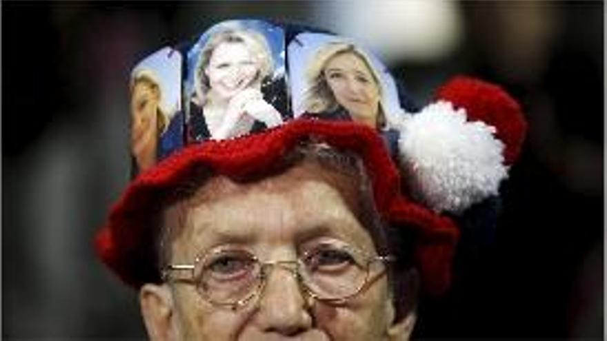 Una dona llueix un barret amb fotos de Marine i Marion Le Pen.