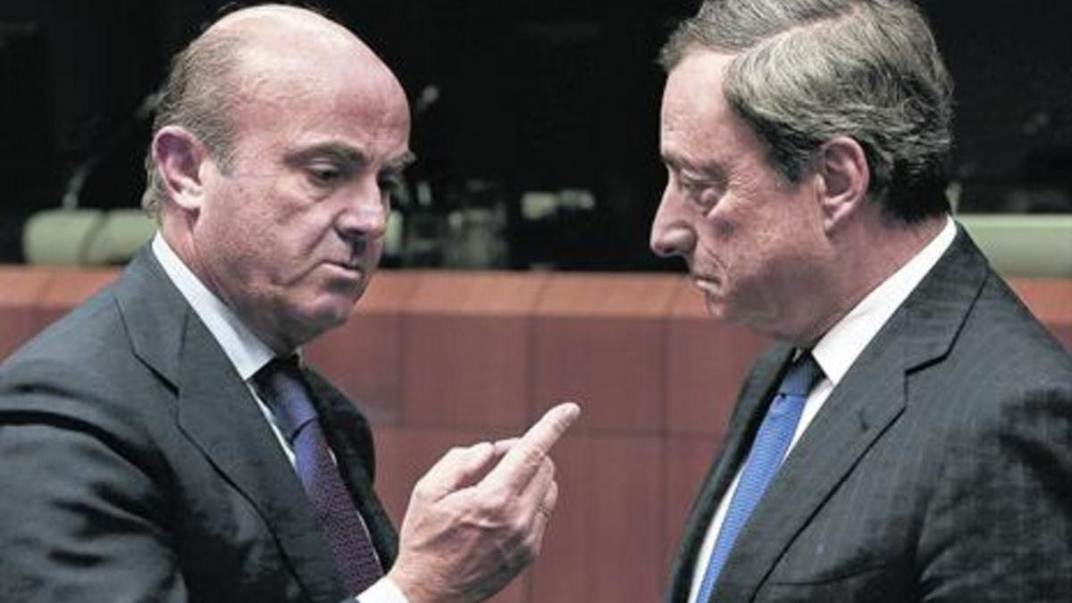 El ministro de Economía español, Luis de Guindos, y el presidente del BCE, Mario Draghi, durante una reunión del Eurogrupo.