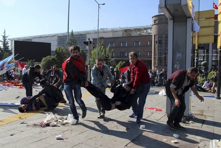 People carry an injured man after an explosion during a peace march in Ankara