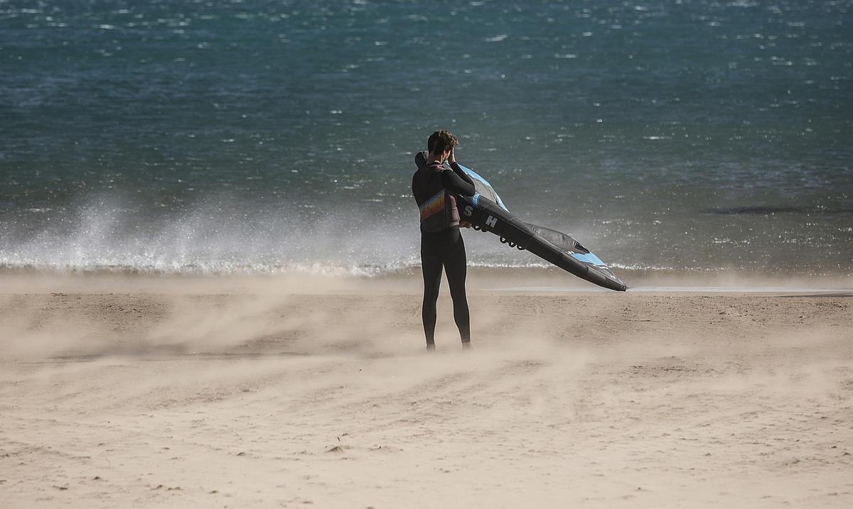 Un hombre en la playa de la Malvarrosa, mientras hay fuertes rachas de viento.