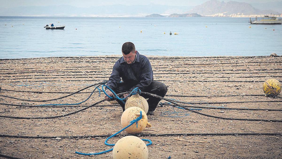 Un pescador realizando trabajos previos a la pesca en La Azohía.