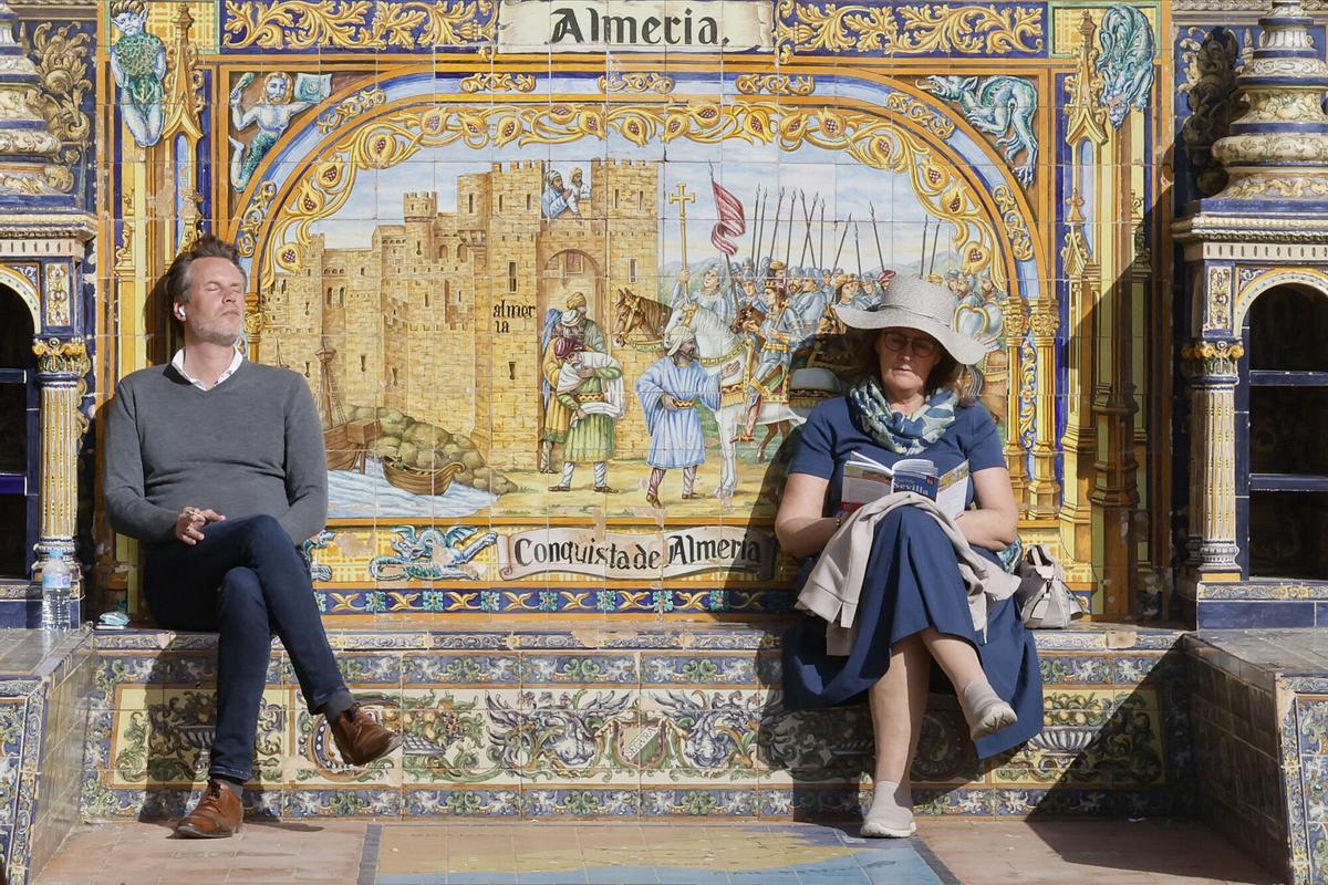 Turistas aprovechan el buen tiempo para tomar el sol en la Plaza de España.