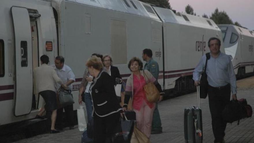 Varios viajeros bajan del tren en la estación de San Pedro de las Herrerías.