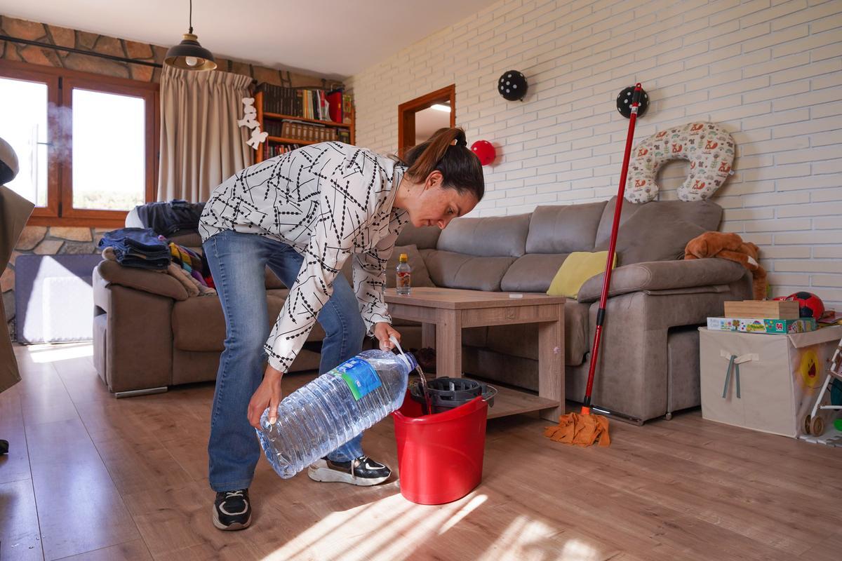 Otra vecina, Núria Beltran, usa agua almacenada en garrafas para fregar.