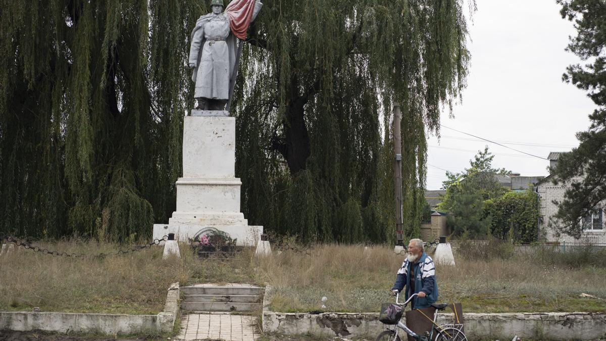 Un residente de Izium pasa frente a una estatua de la Segunda Guerra Mundial, este jueves.