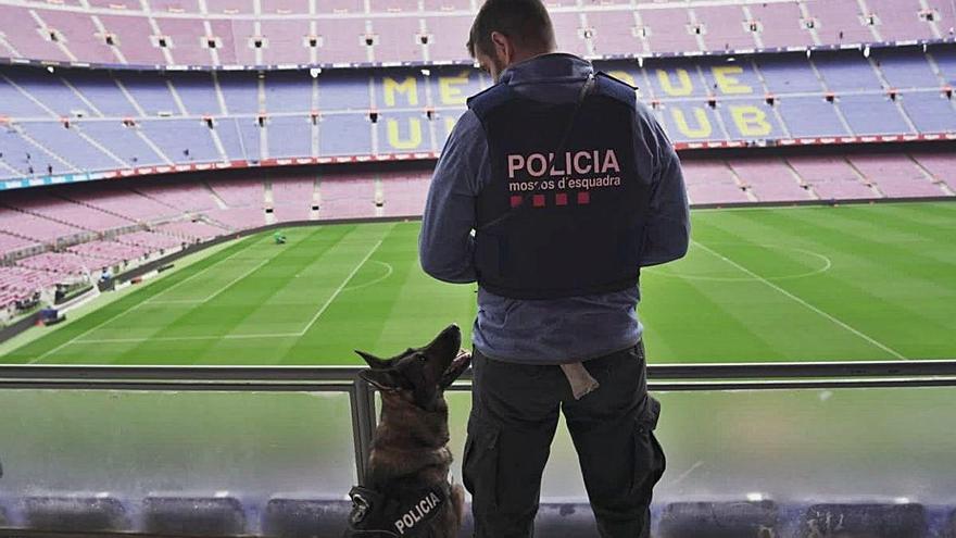 Un agent de Mossos vigilant el Camp Nou sense públic.