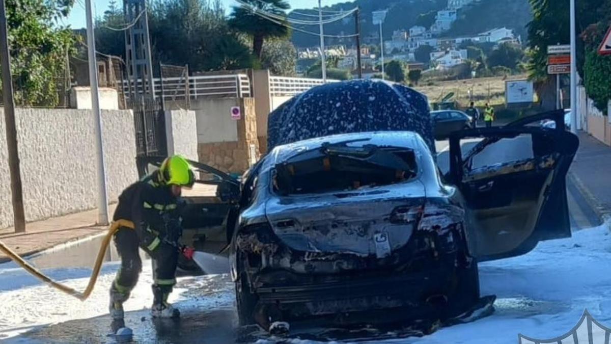 Intervención de los bomberos en el coche, que quedó calcinado