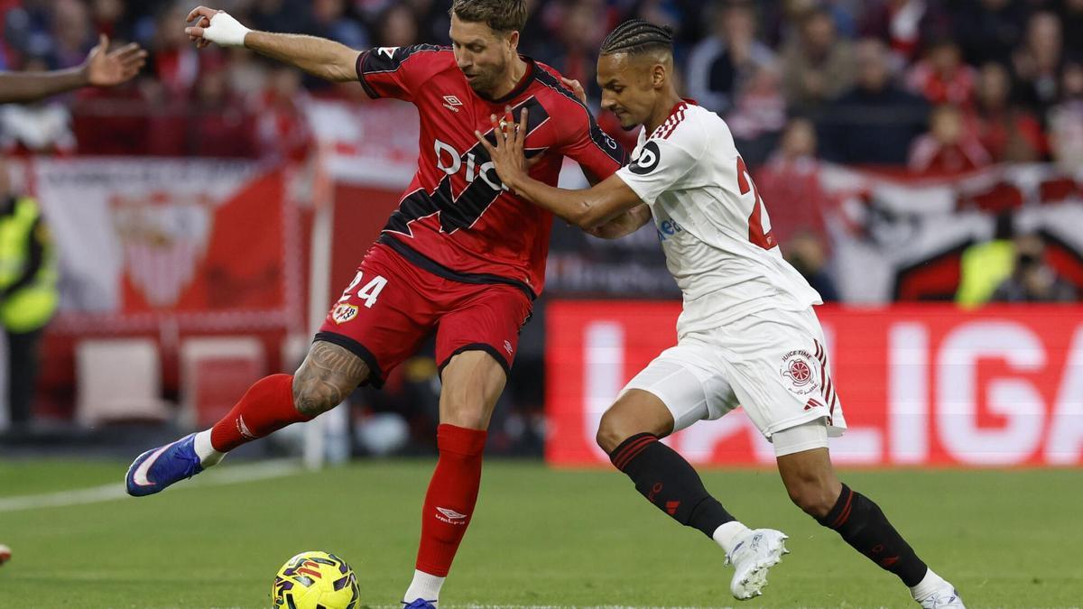 El defensa francés del Rayo Florian Lejeune (i) lucha con el suizo Djibril Sow, del Sevilla.