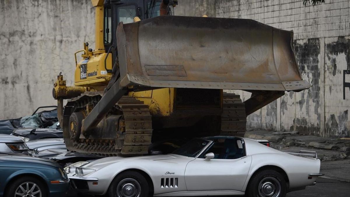 Una grúa aplastando los coches en Manila.