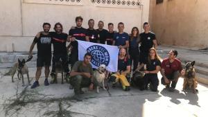 Foto de grupo de los 11 bomberos y los 3 perros buscapersonas de Bombers pel Món de Valencia.