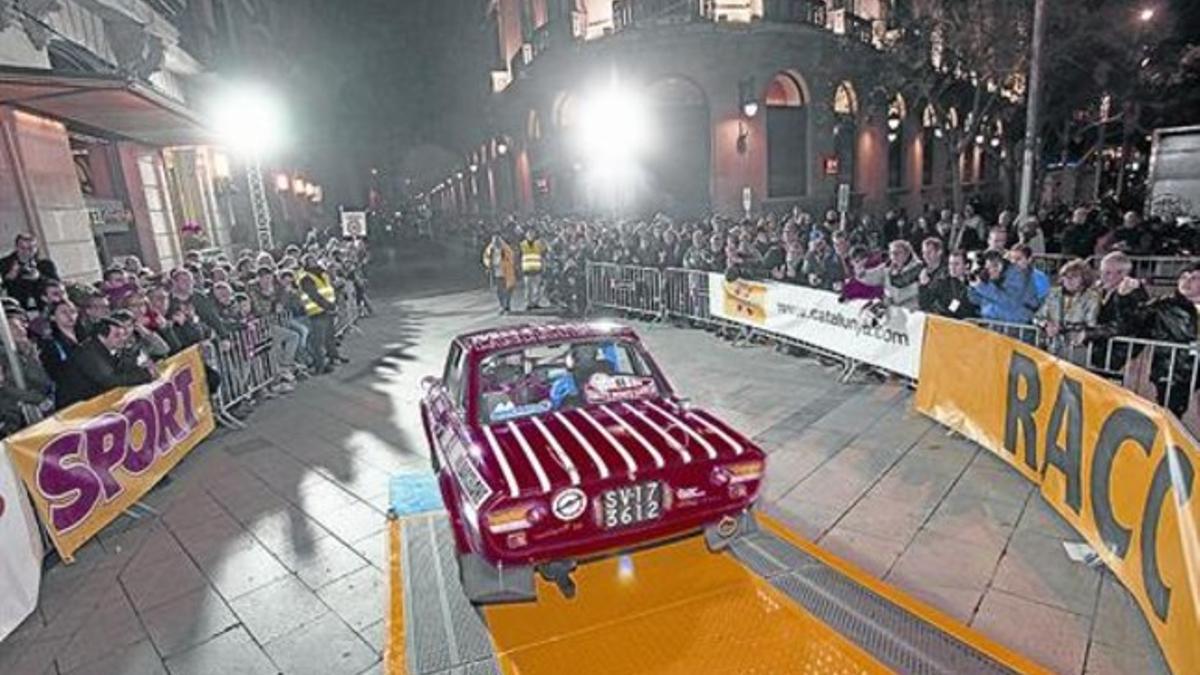 Salida de un vehículo en la avenida de la Catedral, en una edición anterior del rali. Abajo, cartel del 2015.