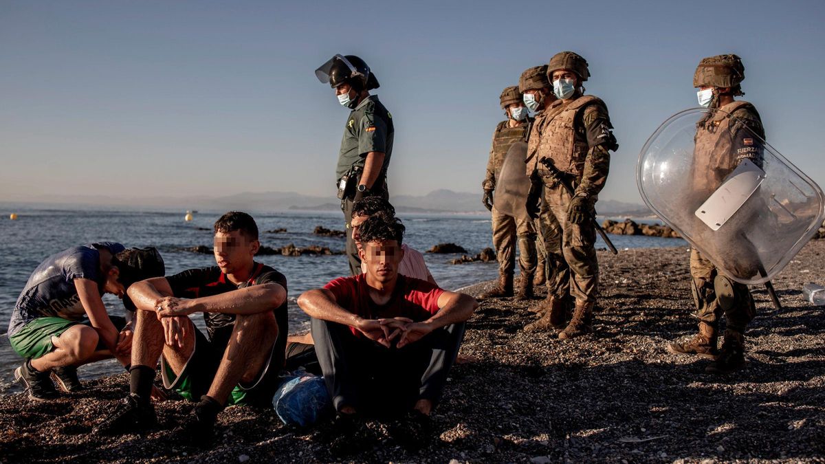 Varios migrantes llegados de Marruecos en la playa del Tarajal.