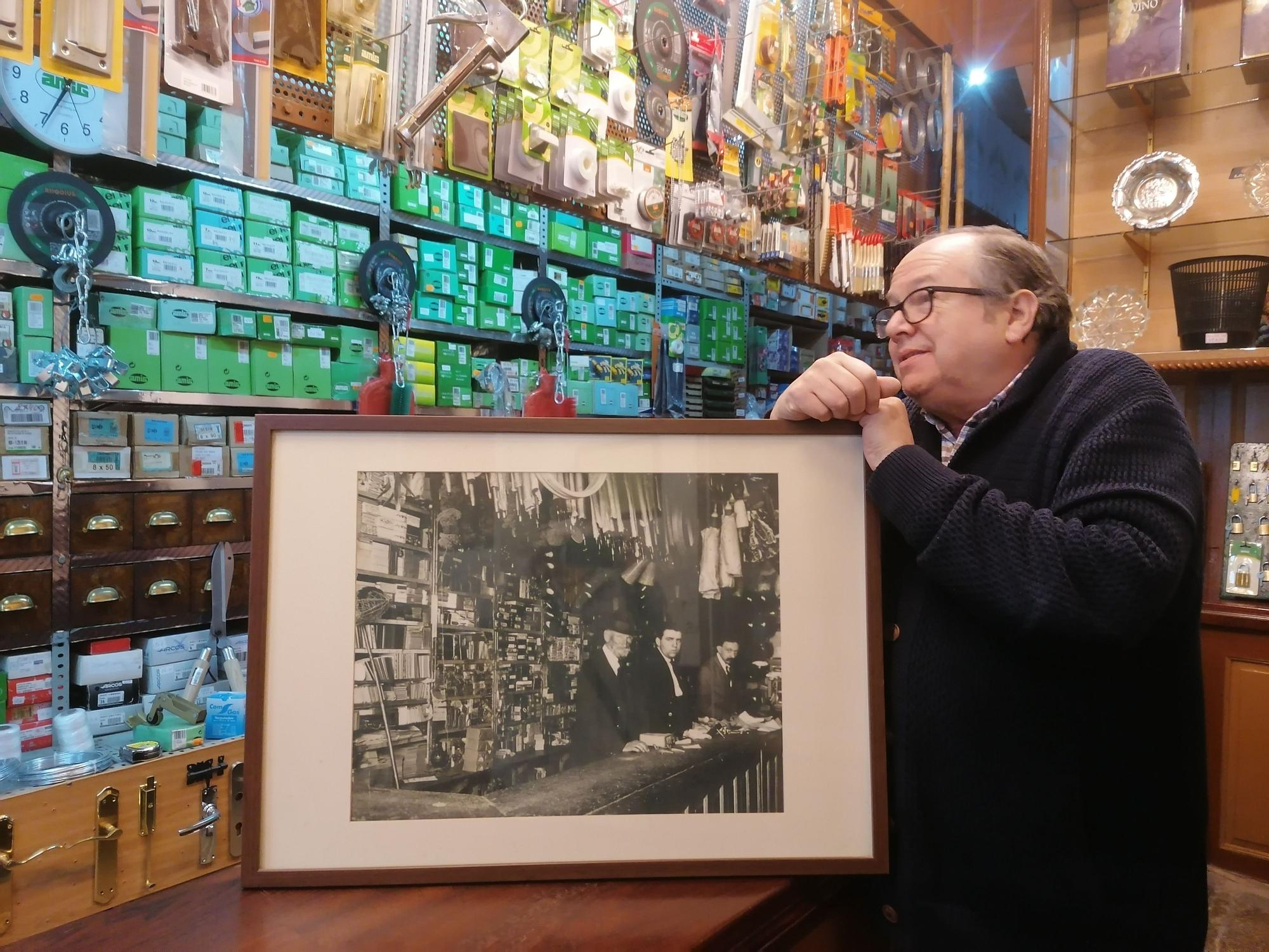 Ignacio Núñez junto a una foto de los pioneros en este negocio familiar